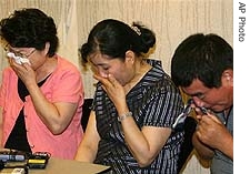 Relatives of South Koreans kidnapped in Afghanistan cry during a news conference