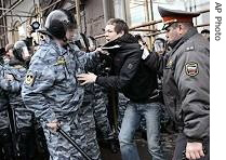 Riot police officers detain Reuter photographer during a protest in Moscow, 14 Apr 2007